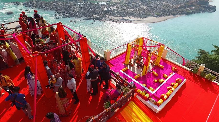 Red floral wedding mandap by the water